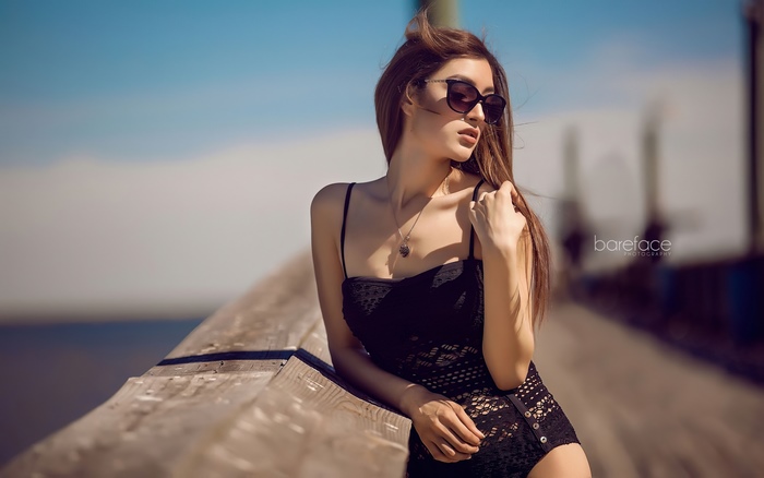 Model in black swimsuit on a pier