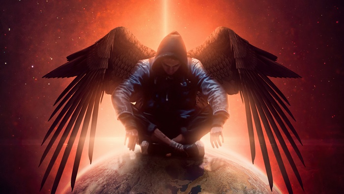 Angel sitting on Earth with wings