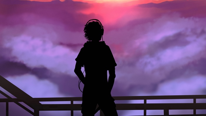Silhouette of a person with headphones against a sunset sky