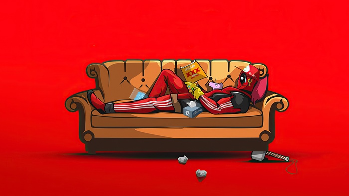 Deadpool relaxing on a couch with a magazine and tissues