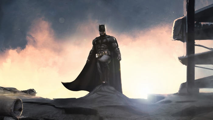 Batman standing on rubble at sunset