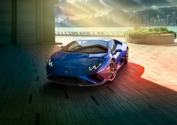 Blue Lamborghini Huracan parked by a waterfront city