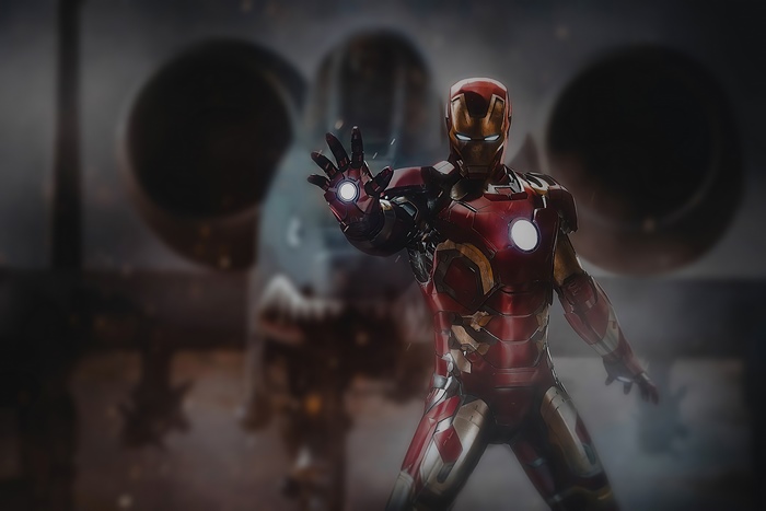 Iron Man in a hangar with other suits