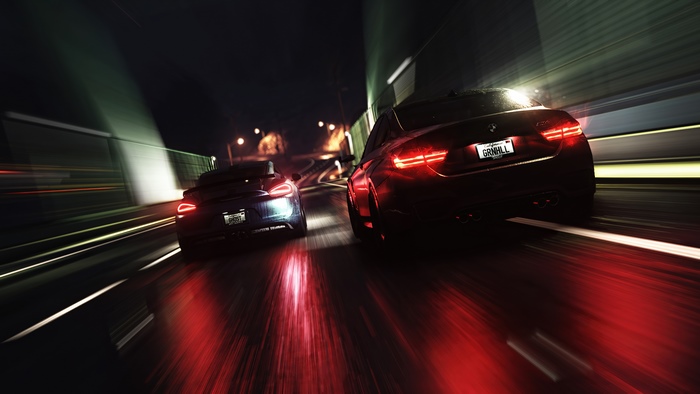 Two cars racing at night on a wet road