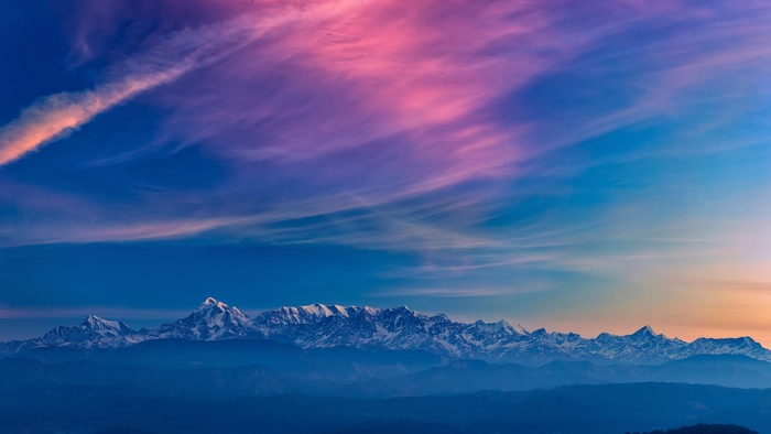 Snow-capped mountains under a colorful sky