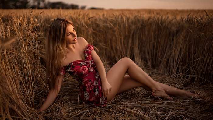 Woman in floral dress in wheat field