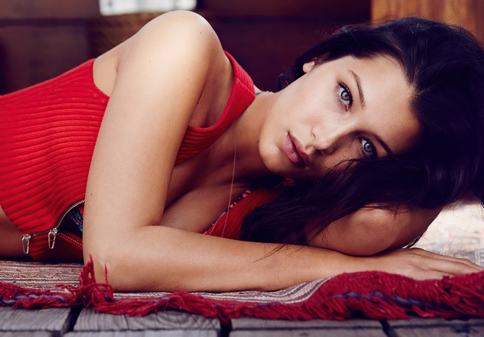 Bella Hadid lying on a rug