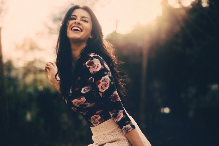 Woman smiling in floral top and lace skirt