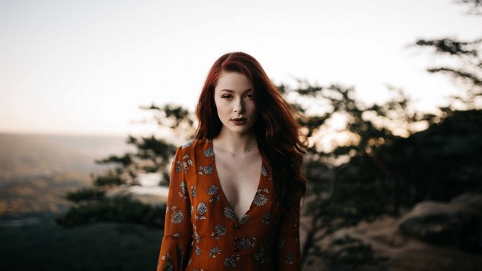 Woman with red hair in a floral dress outdoors