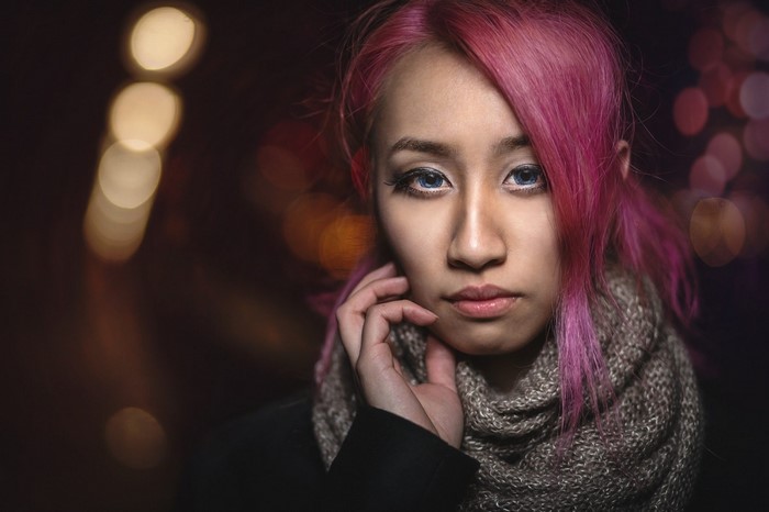 Woman with pink hair and blue eyes wearing a scarf
