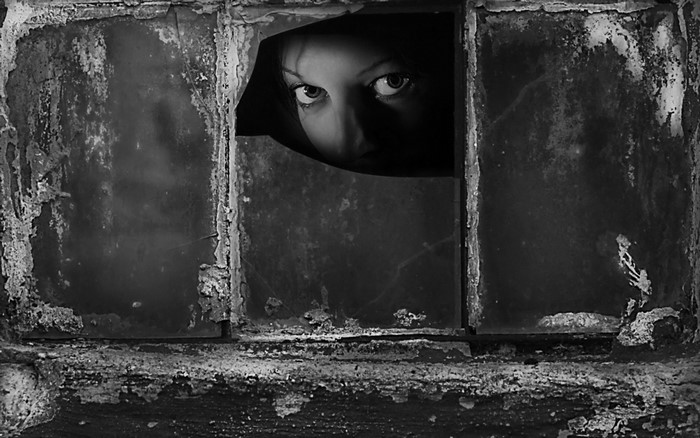 Woman peeking through broken window