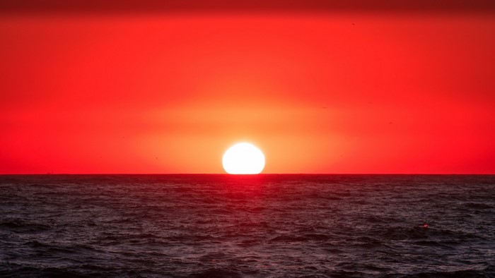 Sunset over the ocean with red sky