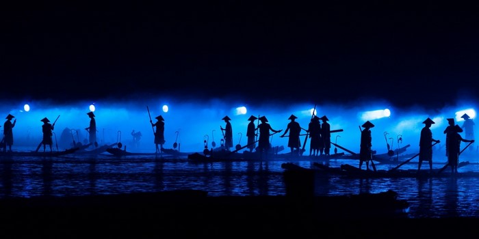 Fishermen in boats at night with blue lights