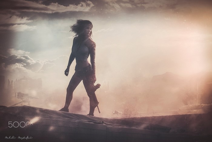 Woman with weapon in a dusty, atmospheric landscape