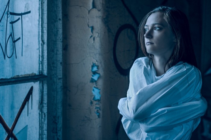 Woman in straitjacket in abandoned building
