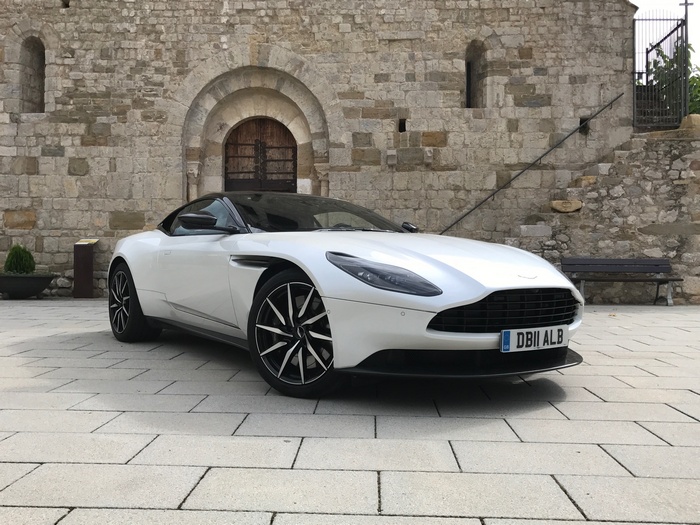 White Aston Martin DB11 V8 parked in front of stone building