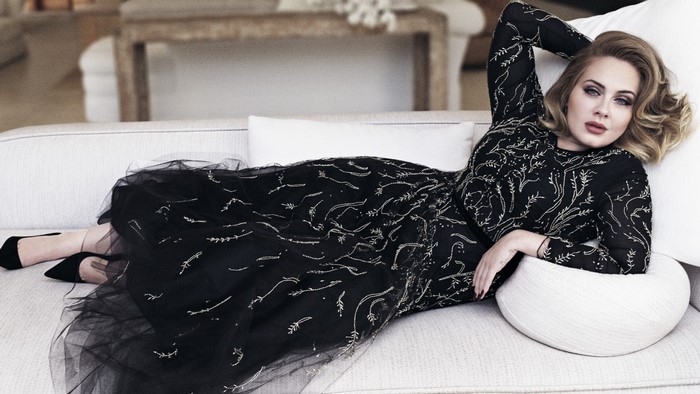 Adele in a black dress on a couch