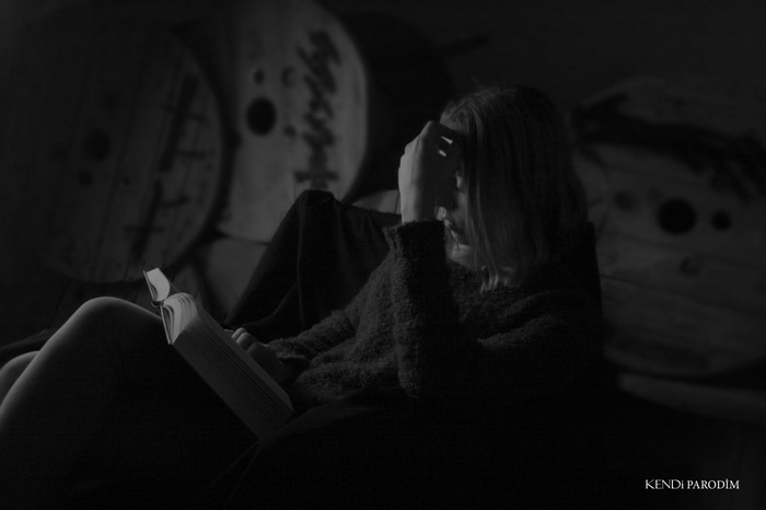 Woman reading a book in dim light