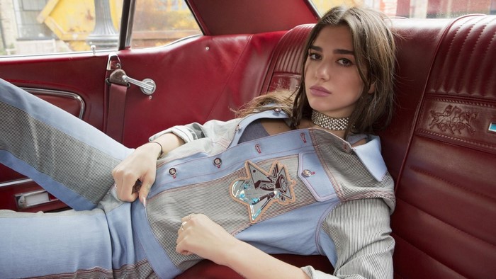 Dua Lipa sitting in a car interior