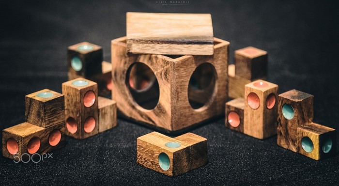 Wooden puzzle cubes and a central cube with holes