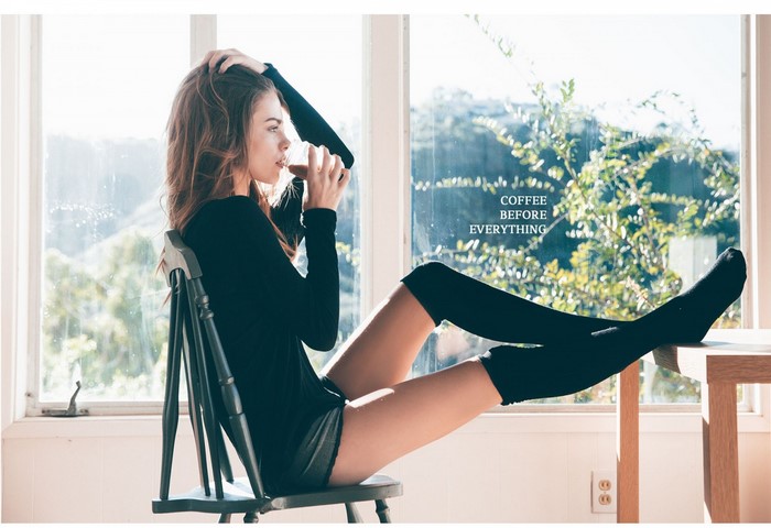 Woman in Black Clothing Drinking Coffee by Window