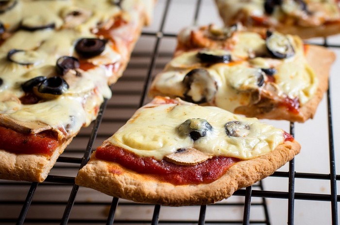 Close-up of slices of pizza with mushrooms and olives