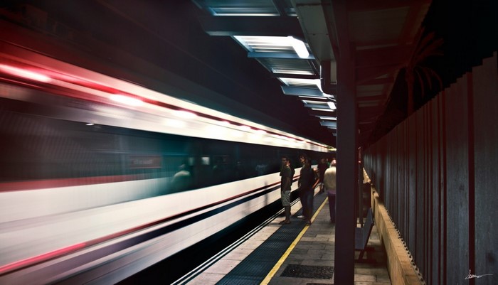 Train station with people and a moving train