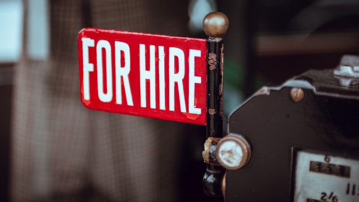 Red 'For Hire' sign on a pole
