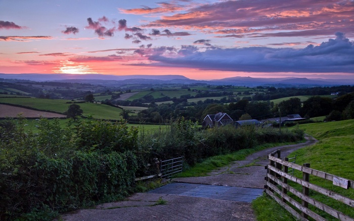 Sunset over rolling green hills and farmland