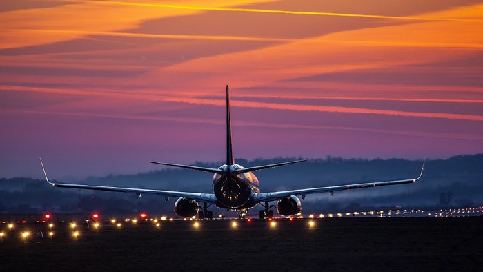 Airplane on runway at sunset