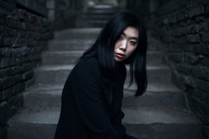 Asian woman in black coat on stairs