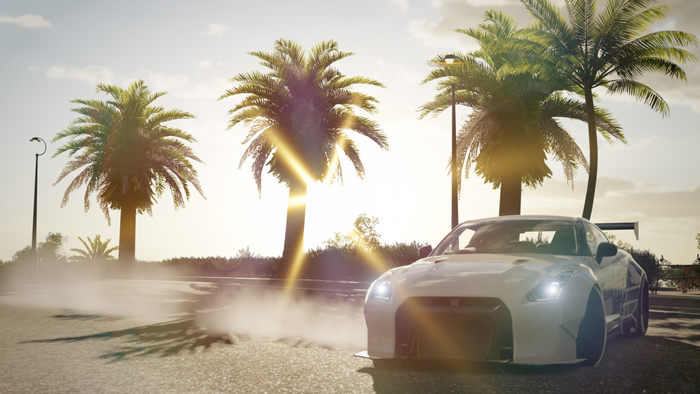 White Nissan GT-R drifting with palm trees at sunset