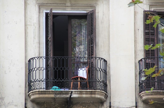 Balcony with open shutters and chair