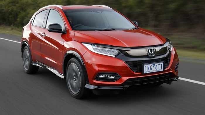Red Honda HR-V SUV driving on a road