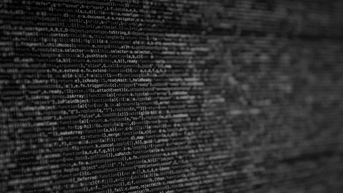 Monochrome computer code on a blurred background