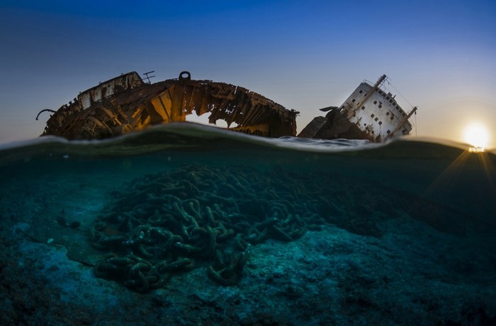 Shipwreck with chains underwater at sunset