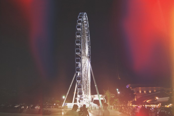 Ferris wheel at night with light flares