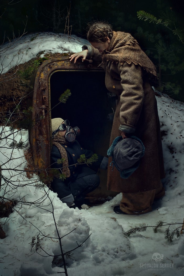 Two people in gas masks in a snowy forest