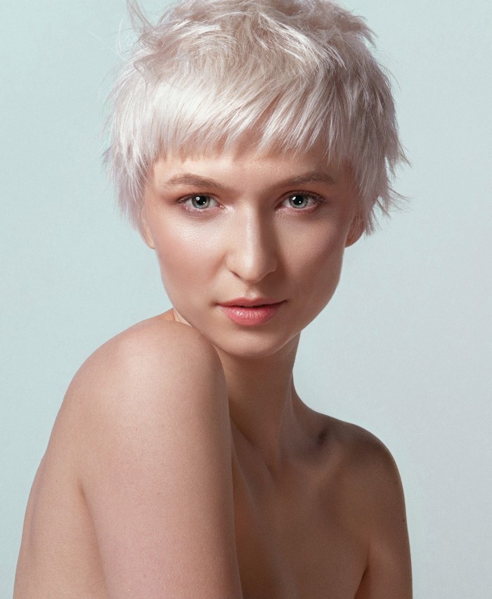 Woman with short blonde hair and bare shoulders