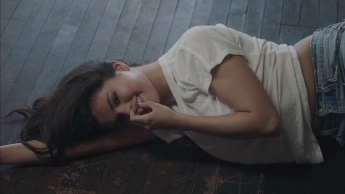 Selena Gomez lying on wooden floor