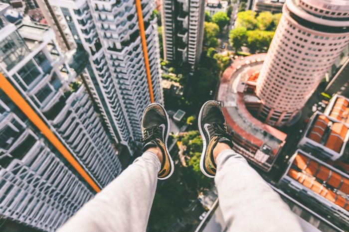 Person's feet dangling over a city skyline