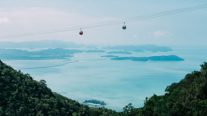 Cable cars over islands and sea with mountains