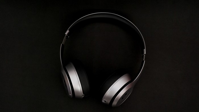 Silver and black Beats headphones on a black background