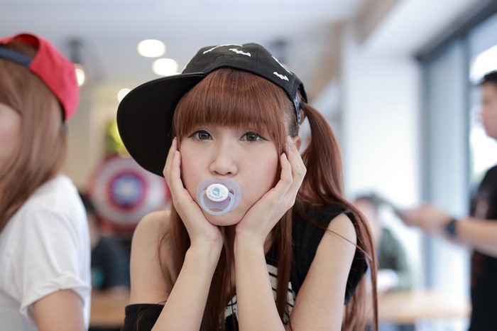 Asian girl with pacifier wearing a baseball cap