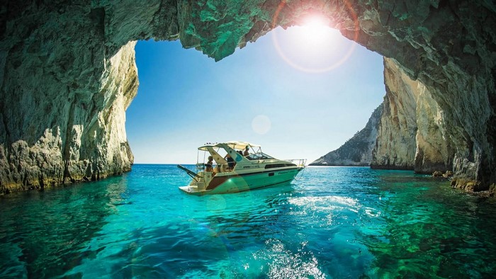 Boat in a turquoise sea cave in Zakynthos, Greece