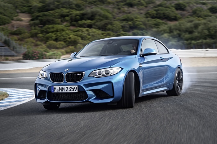 Blue BMW M2 Competition drifting on a track