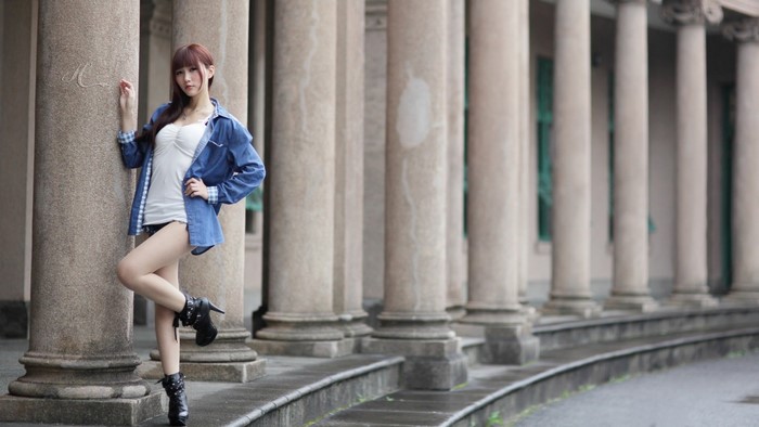 Woman in Blue Shirt and Camisole by Stone Columns