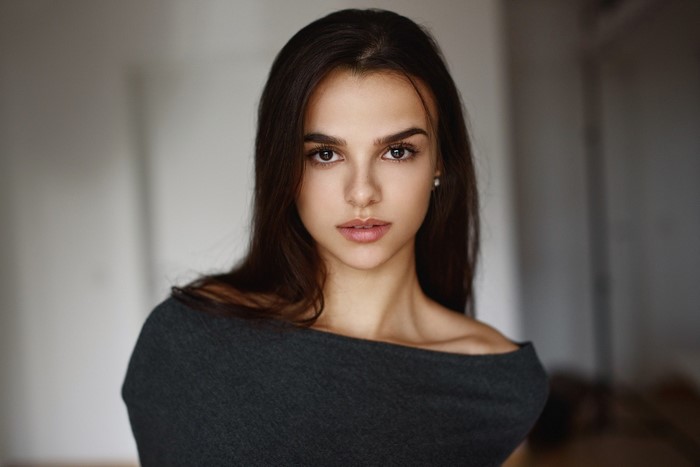 Woman with long dark hair wearing a grey top
