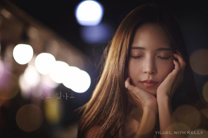 Woman with eyes closed in bokeh lighting