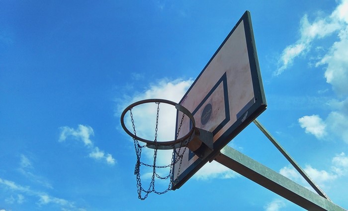 Basketball hoop with chain net against blue sky